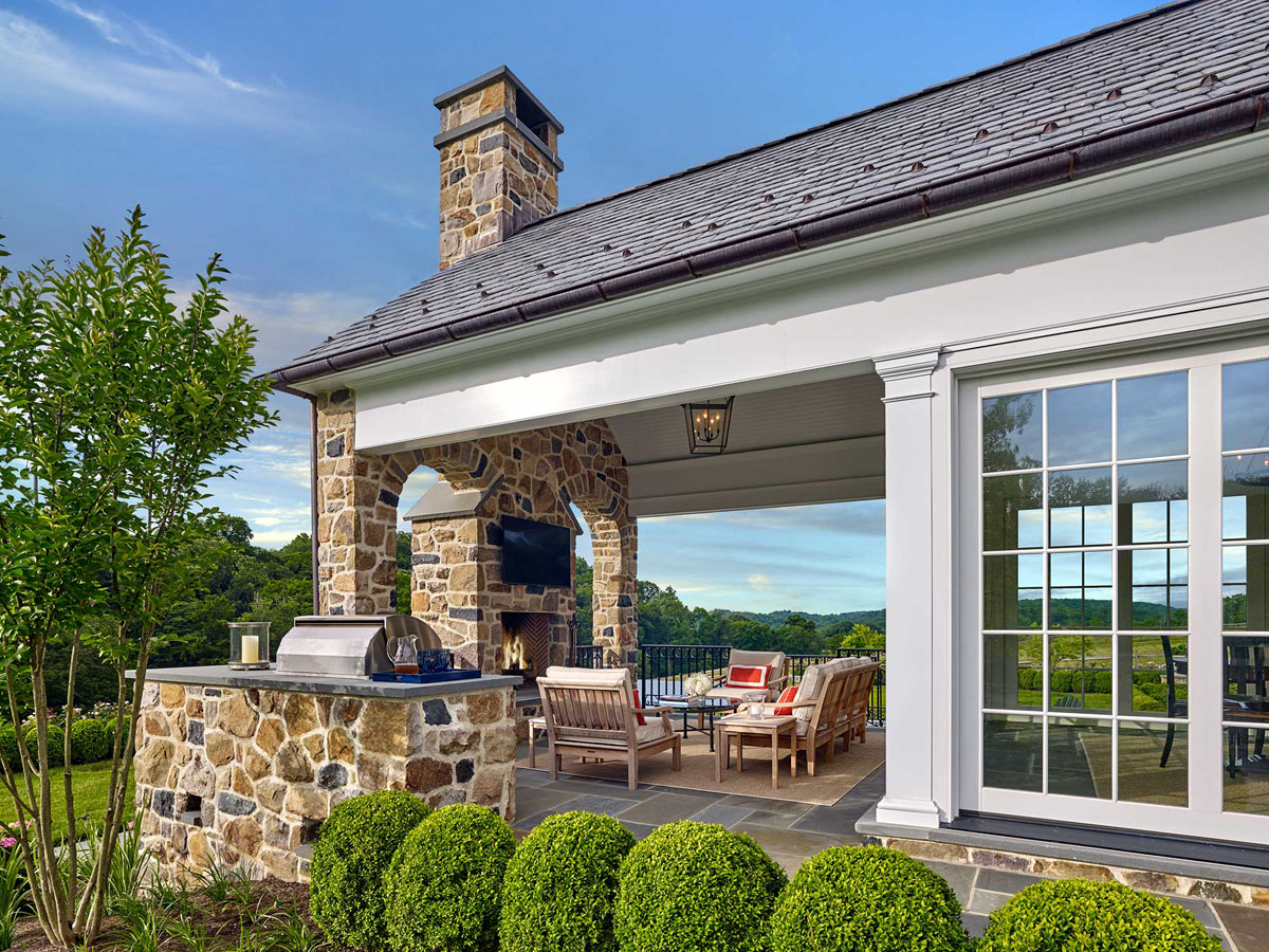 Glass-Enclosed Sunroom Adjoins a Covered Terrace